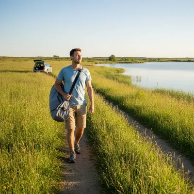 An inflatable kayak being easily transported in a compact bag by a person walking towards a lake with a car in the background, showcasing convenience and portability.